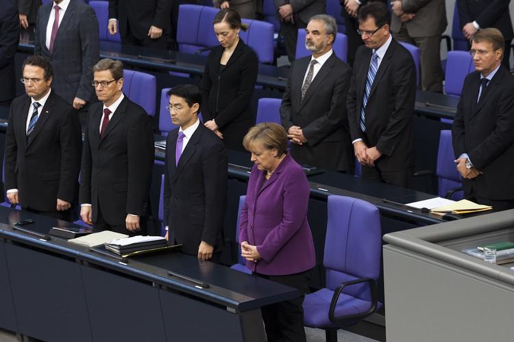 Undskyld. Det tyske parlament med forbundskansler, Angela Merkel, i spidsen rejser sig, efter at erklæringen er blevet vedtaget i enighed af alle 620 medlemmer. 