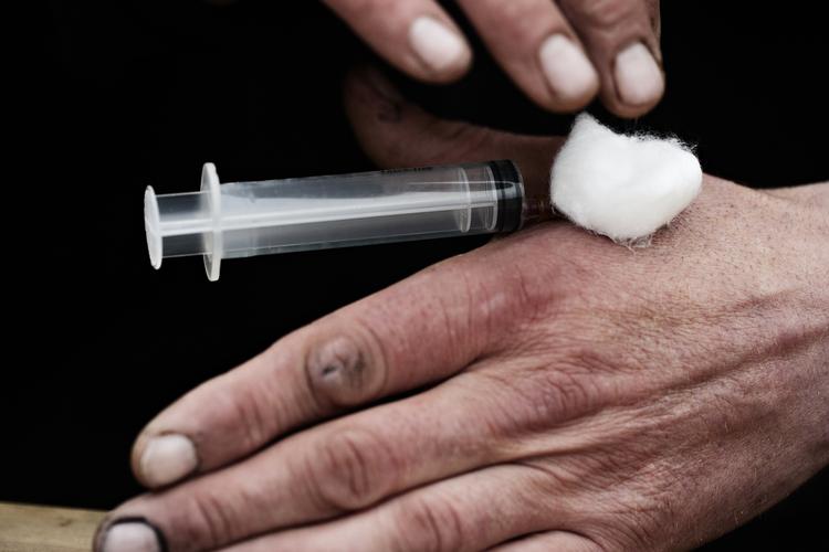 afhængighed. En 46-årig narkoman ved navn Kim fixer sig selv i hånden. 