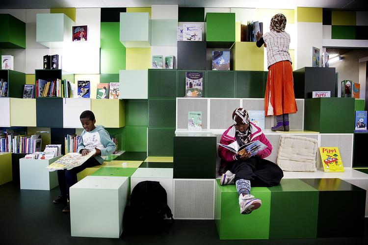 Stemningsfuldt . I børnebiblioteket klatrer man på  boghylderne. Husets gyldne æsker  indeholder hver sit  tegnede interiør. Foto: Stamers Kontor 