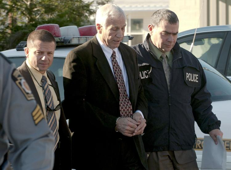 voldtægter. Den hædrede fodboldtræner Jerry Sandusky (midt) føres væk i håndjern af politi 5. november, efter en række sager om pædofilt misbrug er dukket op om den tidligere træner. 