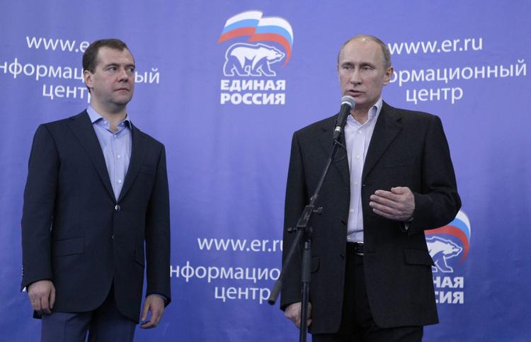 Vælgerlussing. Russiske vælgere har tildelt premierminister Vladimir Putin (th.) og hans regeringsparti Forenet Rusland en markant politisk begmand ved søndagens parlamentsvalg i Rusland. 
