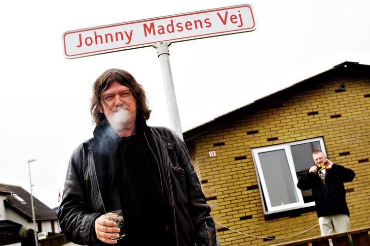 International. Johnny Madsens nyeste album er inspireret af en tur til USA. Pladen er til gengæld indspillet i Paris. Her ses den legendariske sangskriver i fødebyen Thyborøn, hvor han har fået en vej opkaldt efter sig. 