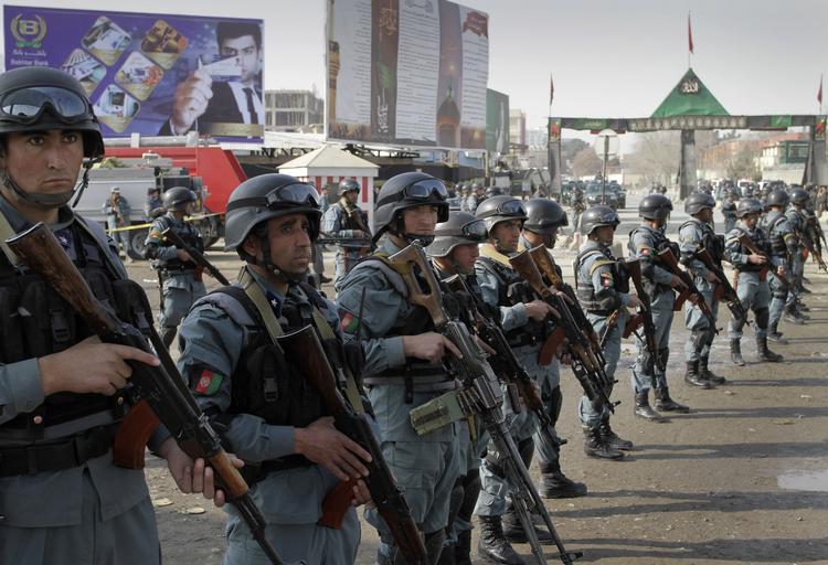 Vagt. Afghanske betjente står vagt ved det shiamuslimske tempel i Kabul, der blev ramt af en af terrorbomberne. 