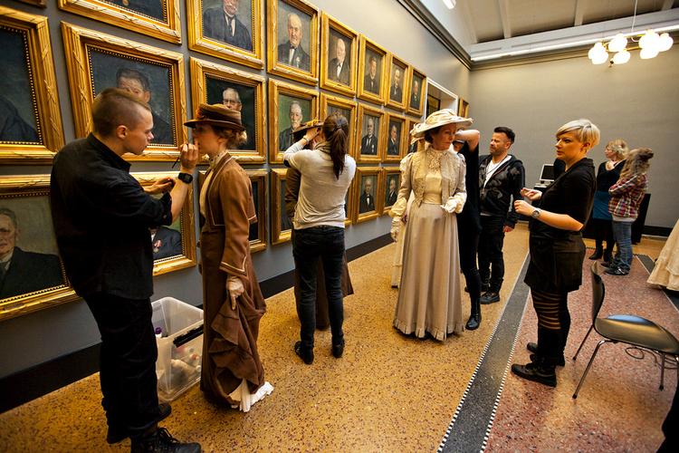 Snurbart og hårspray. Til lejligheden har de kvindelige gæster iført sig prægtige rober af uld og silke. Herremoden dikterer jakkesæt eller kjole og hvidt, gerne ledsaget af imposante snurbarter og kindskæg. Nogle behøver hjælp af parykmageren, andre scenevante statister har anlagt passende ansigtsbehåring hjemmefra. Chefsminkør Dennis Knudsen udnytter de sidste ledige sekunder til at indhylle en kvindelig statist i skyer af hårspray. Velkommen! De dybrøde vægge i Ragnaroksalen danner ramme om den scene, der introducerer Birgitte Hjort Sørensen og Søren Sætter-Lassen som fru og hr. P.S. Krøyer. Det er skagensmalerens første københavnske fernisering i 1902, vi er vidne til. »En af årets store begivenheder«, siger overretssagfører Viggo Lachmann (Tommy Kenter) i sin tale til det overdådige arrangement. Dagens optagelse udgør produktionens største udstyrsstykke med godt 50 statister. 