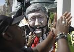 Protester. Demonstranter følger med i topmødet i Durban. Her har en aktivist iført sig en maske af den canadiske premierminister Stephen Harper. 