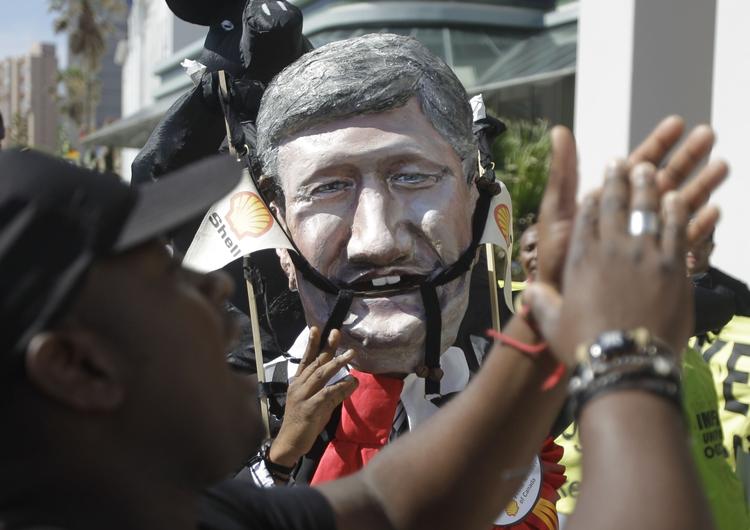Protester. Demonstranter følger med i topmødet i Durban. Her har en aktivist iført sig en maske af den canadiske premierminister Stephen Harper. 