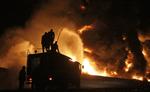 Oliebrand. Pakistanske brandfolk forsøger at få slukket brand i olietankvogne efter angreb fra ukendte gerningsmænd. 