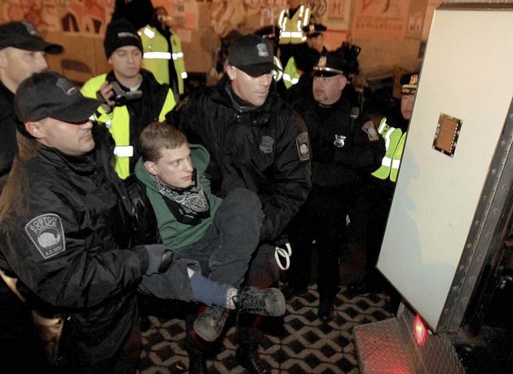 RYDNING. Aktivist fra Occupy Boston bæres ind i salatfad under rydningen af protestlejren. 