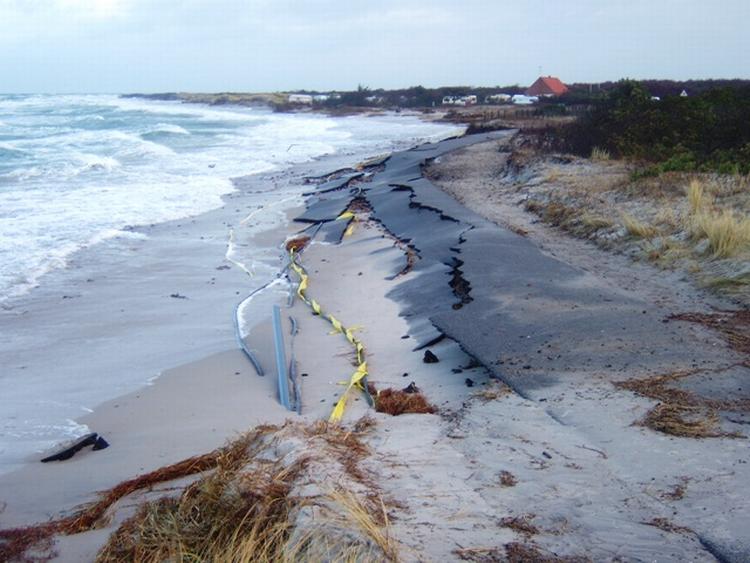 STORMSKADE. Nordstrandvejen på Anholt er gnavet væk under nattens stormvejr. Det har afbrudt hovedfærdselsåren til havnen - og ramt el- og vandforsyningen. 
