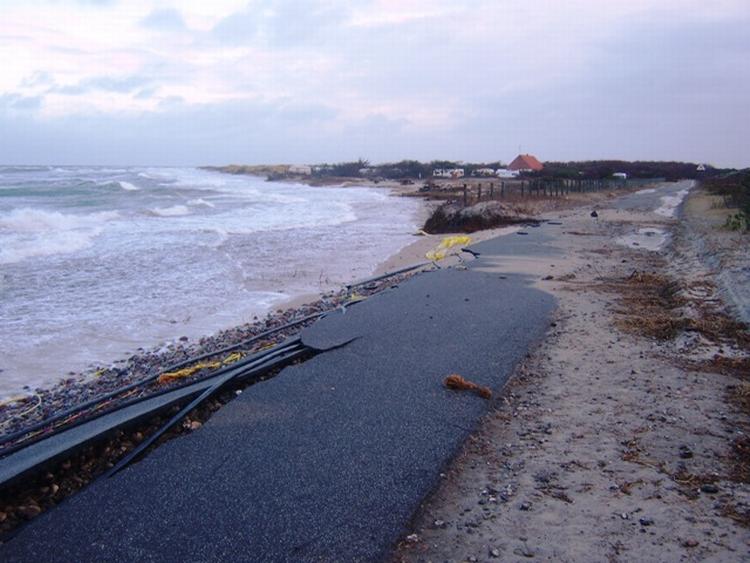 ØDELÆGGELSER. Den kraftigt beskadigede Nordstrandvej. Billedet viser, hvor langt ind mod landet havdet har ædt sig sammenlignet med det får år gamle foto i bunden af artiklen. 