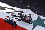 opstand. Her ses prodemokratiske demonstranter under det syriske flag i forbindelse med en demonstration i Damaskus i sidste måned. Ifølge FN er omkring 5.000 døde som følge af opstanden i Syrien - herunder 300 børn. 