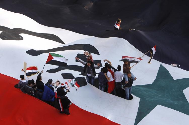 opstand. Her ses prodemokratiske demonstranter under det syriske flag i forbindelse med en demonstration i Damaskus i sidste måned. Ifølge FN er omkring 5.000 døde som følge af opstanden i Syrien - herunder 300 børn. 