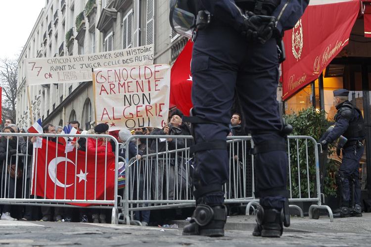 Vrede. Vrede tyrkiske demonstranter protesterer mod det franske parlaments beslutning om at kalde massemord på armeniere for 'folkedrab'. 