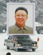 Et stort protræt af 'Den store leder' er med i sørgeoptoget. 