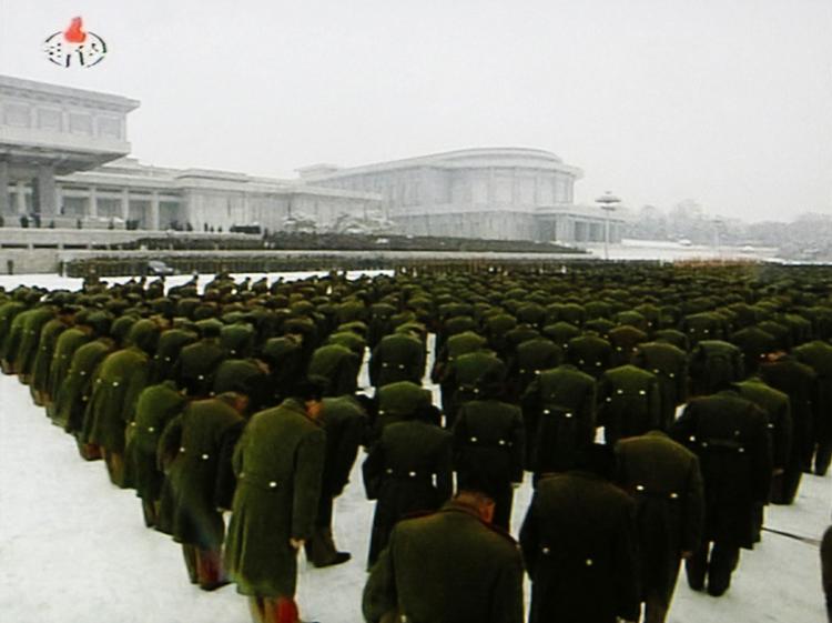 Soldater bøjer hovedet i ærbødighed på den centrale plads i Pyongyang. 
