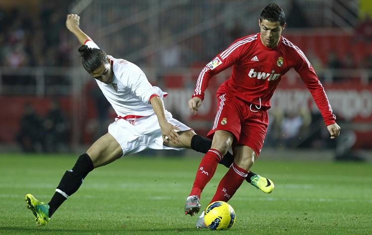 tilpas. Livet i verdens bedste liga  passer glimrende til Cristiano Ronado (th.), der her er i duel med Martin Caceres fra Sevilla. 