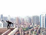 Superhelt. Heroisk venter manden med leen på toppen af en bygning  i Guangzhou. Men det er bare en leg. 
