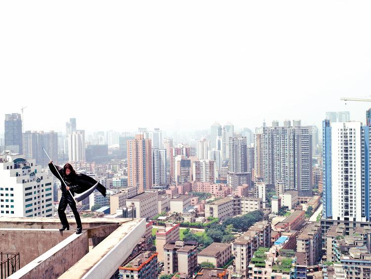Superhelt. Heroisk venter manden med leen på toppen af en bygning  i Guangzhou. Men det er bare en leg. 