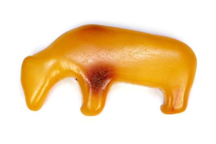 ravbjørnen. Slidfuren om halsen har en skuret karakter og et usammenhængende forløb. Selve ravstykket er sandsynligvis savet ud af et større stykke rav som et endestykke. 