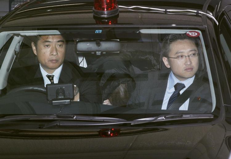 Kult. Makoto Hirata (th) ses her på vej til at blive overført til en anden politistation. Nytårsdag meldte han sig til politiet efter 16 et halvt år på flugt. 