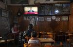 Udmelding. Lokale borgere ser præsident Bashar al-Assads tale på en café i Syriens hovedstad, Damaskus. 