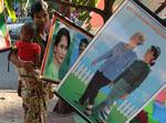 Populær. Aung San Suu Kyi er meget populær i Myanmar, som tidligere hed Burma, inden militærdiktaturet ændrede navnet i 1989. Her kiggger en mor og hendes søn på plakater i landets hovedstad Yangon. 