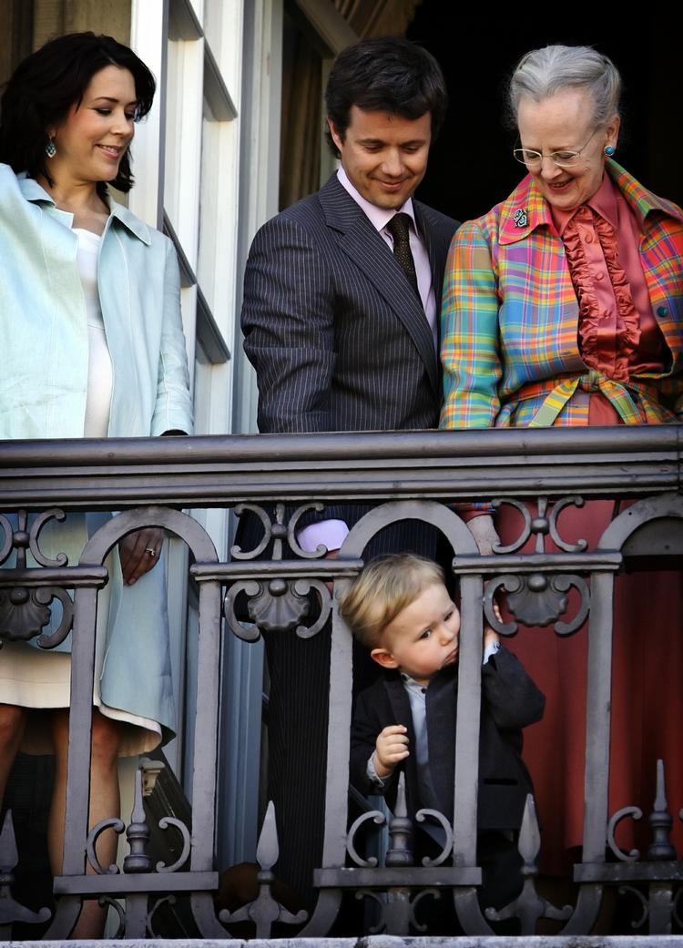 Den lille prins stikker sit hoved ud mellem stængerne på balkonens gelænder ved samme lejlighed. 