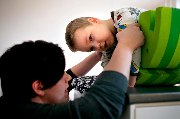 Iltmangel. En fejl under fødslen gav Axel en hjerneskade. Ubærligt for moren, Linda Jensen, der her træner med sin søn. »Det er jo nogens skyld, at vores liv er helt, helt anderledes, end vi havde regnet med«, siger hun. 