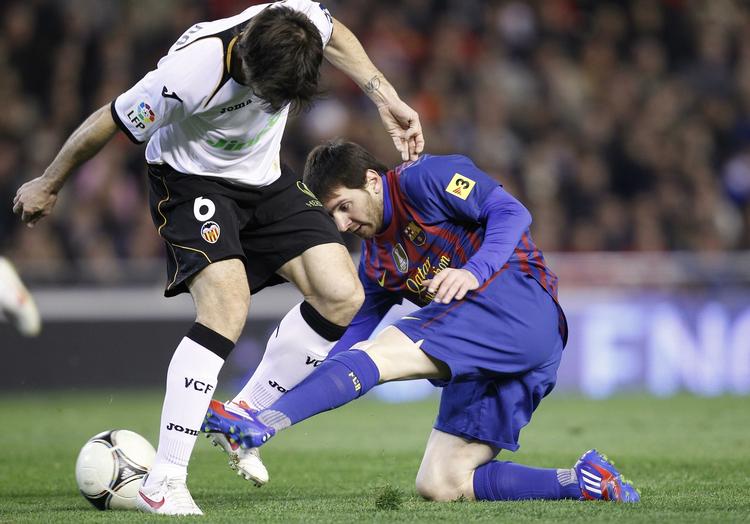 Ups. Lionel Messi blev den lille i denne duel med Valencias rutinerede David Albelda. Messi, der allerede har scoret 36 mål i 35 kampe i denne sæson, kiksede desuden fra straffesparkspletten. 