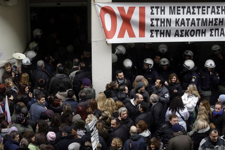 Krise. Statsansatte læger strømmer ind i det græske sundhedsministerium under en protestaktion. De store nedskæringer er stærkt upopulære blandt de statsansatte. 