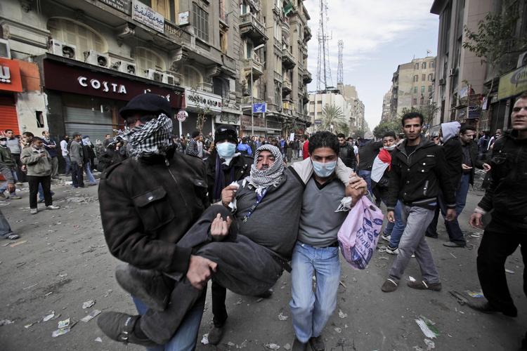 VOLD. Egyptiske demonstranter bærer en såret til et felthospital i Kairo. Tusindvis er blevet såret i urolighederne de seneste dage. 
