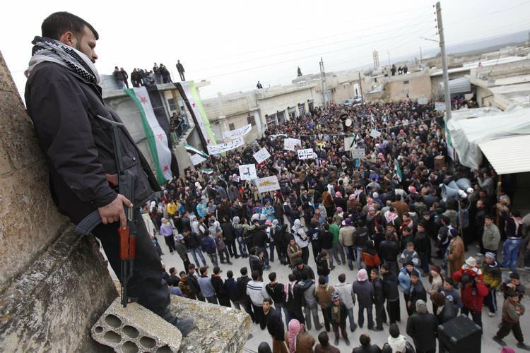Protest. Et medlem af den syriske undergrundshær holder vagt over en demonstration mod regeringen i byen Idlib. 