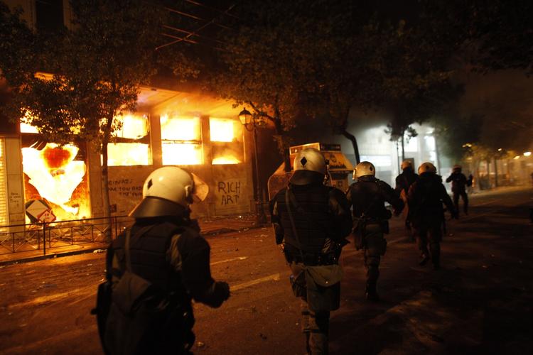 Uro. Flere bygninger blev stukket i brand under gadekampene i Athen. 