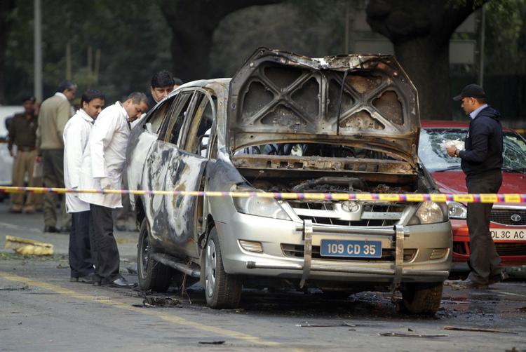 attentat. De indiske myndigheder undersøget den sprængte bil på gaden i New Delhi. 