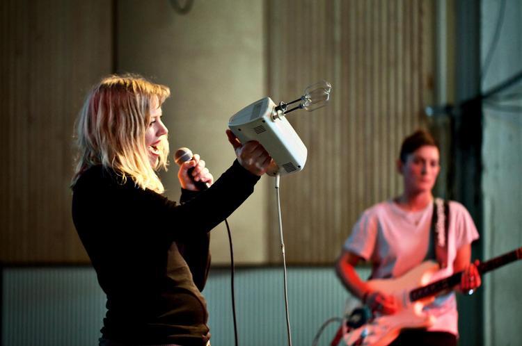 Køkkenmusik. Band Ane alias laptopmusikeren Ane Østergaard   åbnede stormødet i København om de manglende kvinder i rytmisk musik og fremførte bl.a. et nummer på håndmikser. Med sig på scenen havde hun guitarist Else Gaunoux (i baggrunden). 