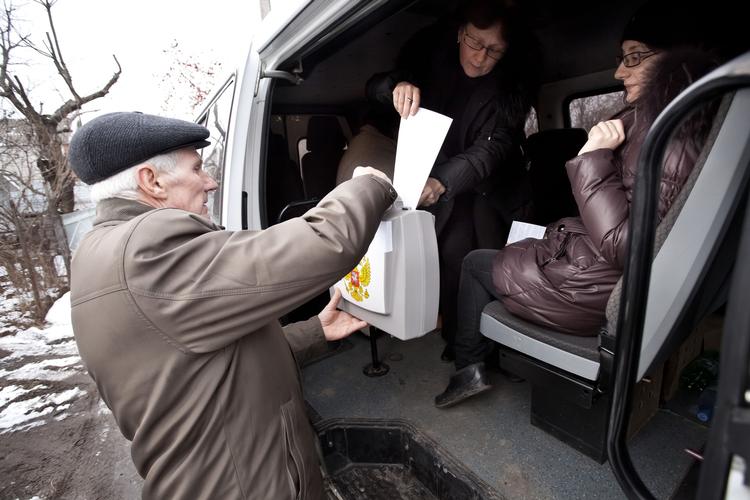 Her lægger vælgere deres stemmer i en bærbar stemmeurne i Timashevsk. 