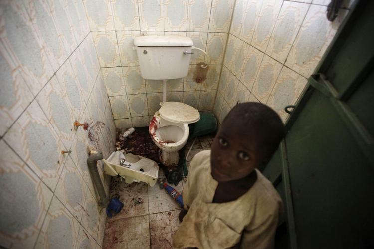 Likvidering. En dreng står ved det toilet, hvor et britisk og italiensk gidsel skal være blevet henrettet af deres gidseltagere under en befrielsesaktion. 