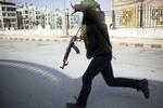 Dialog? I den nordlige by Idlib i Syrien fortsatte kampene i går, mens præsident Assad holdt møde med den tidligere FN-chef Kofi Annan. Her forsøger en syrisk oprører at flygte i dækning under angreb fra Assads tropper. 