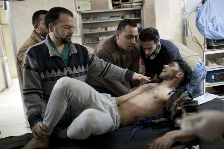 Såret. En oprører bliver tilset af en læge, efter at han blev såret under weekendens kampen i Syrien. 