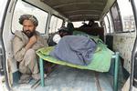 En mand sidder ved båren med en af de 16 dræbte civile afghanere, som faldt ved en amerikansk soldats hånd. 