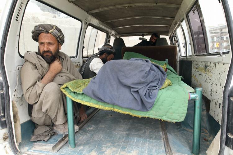 En mand sidder ved båren med en af de 16 dræbte civile afghanere, som faldt ved en amerikansk soldats hånd. 