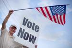 Danny Cooper vinker bilister ind til lokale stemmebokse i Alabama tirsdag. Rick Santorum vandt. David Goldman/AP 