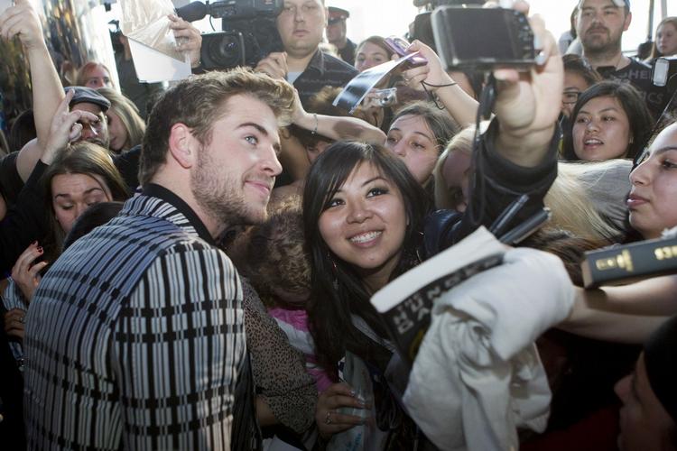 Liam Hemsworth blev fotograferet med nogle af sine fans ved premieren i Toronto. 