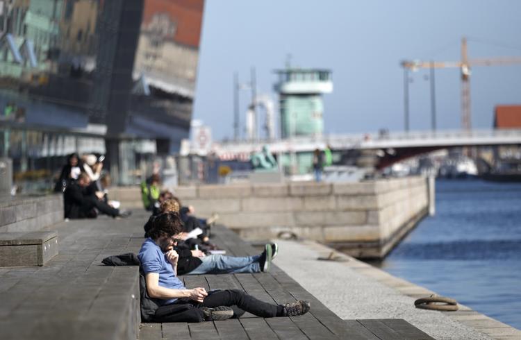 SOMMERTID. Danskerne er de seneste dage strømmet ud på gader og stræder for at nyde det gode vejr. Det er for eksempel her ved Den Sorte Diamant i København. Arkivfoto. 