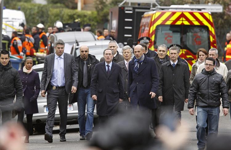 POLITIAKTION. Indenrigsminister Claude Gueant (i midten) ses på vej til et improviseret pressemøde få minutter efter den anholdelsesaktion, der kostede den terrormistænkte livet. 