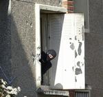 POLITI. Efterforskere har ledt efter spor efter at Merah var bestilt til at udføre angrebene på franske soldater og skolebørn. Her stikker en person fra specialstyrken hovedet ud af det vindue, som Merah havde barrikaderet sig bagved. 