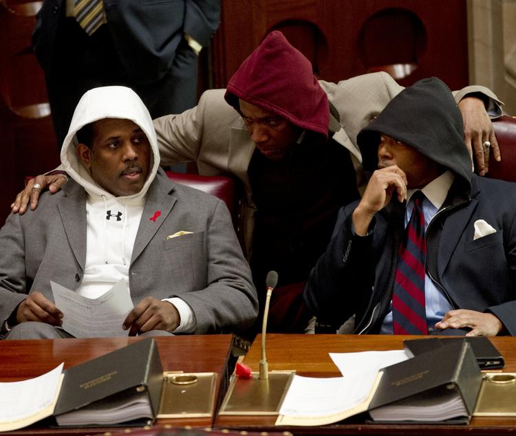 Hætteklædt. Amerikanere bærer hætte for at markere deres modstand mod, at man bliver offer for mistænkeliggørelse, fordi man som Trayvon Martin har hætten oppe. Her er det Senatorerne Kevin Parker (t.v.) Bill Perkins og Eric Adams, der mandag bærer hættetrøjer under habitten i New Yorks senat. Foto: Mike Groll/AP 