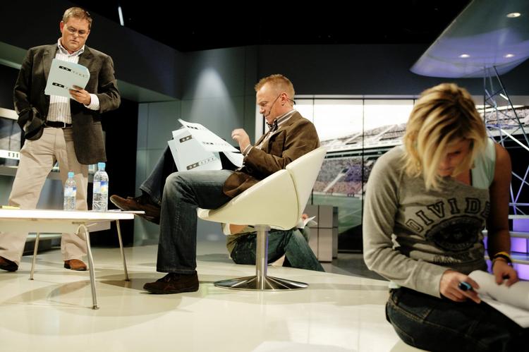 Værter.  Carsten Werge (stående) og Per Frimann (siddende i stol) har i lang tid været værter på TV3.  Her er de i gang med optagelser af fodboldprogrammet 'Onside' i 2004. 