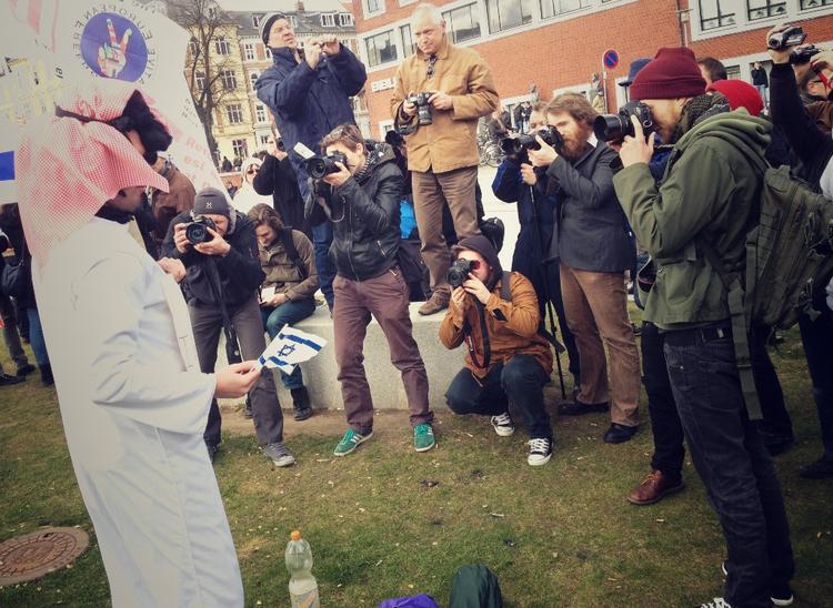 HØJRE-DEMO. En af deltagerne i den islamkritiske demonstration havde klædt sig ud i arabiske klæder. Her fotograferes han af de talrige pressefotografer under demonstrationen i Mølleparken. 