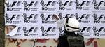 sammenstød. En politimand i Bahrain står foran en væg med protestplakater mod Formel 1-løbet i oliestaten. 